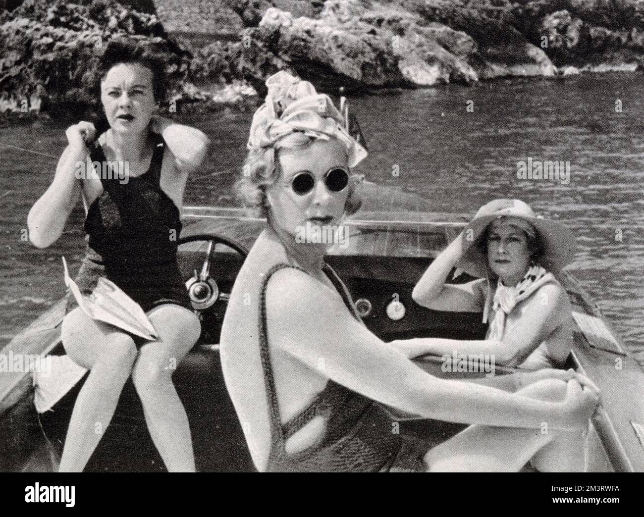 On a speed-boat near the Summer Sporting Club, Monte Carlo, the Hon. Kay Norton (right), Mrs Richard Hoffman of New York (left) and (in the foreground), Lady Castlerosse.  The Sketch remarks that the Summer Sporting Club, opened in the 1920s, is the centre of evening and social life, where one dines out on the terrace to the cabaret of &quot;Les Girls&quot;'.       Date: 1936 Stock Photo