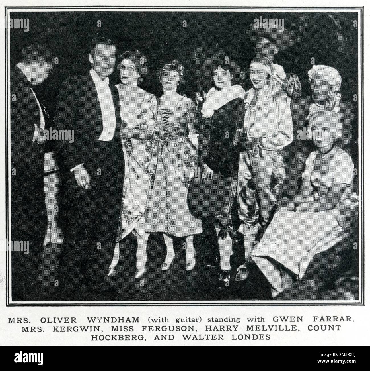 Mrs Oliver Wyndham (with guitar) standing with Gwen Farrar, Mrs Kergwin, Miss Ferguson, Harry Melville, Count Hockberg, and Walter Londes at a party in London aboard the &quot;Friendship&quot;, called by The Tatler a 'Bright Young Party avec dance'.     Date: 1929 Stock Photo