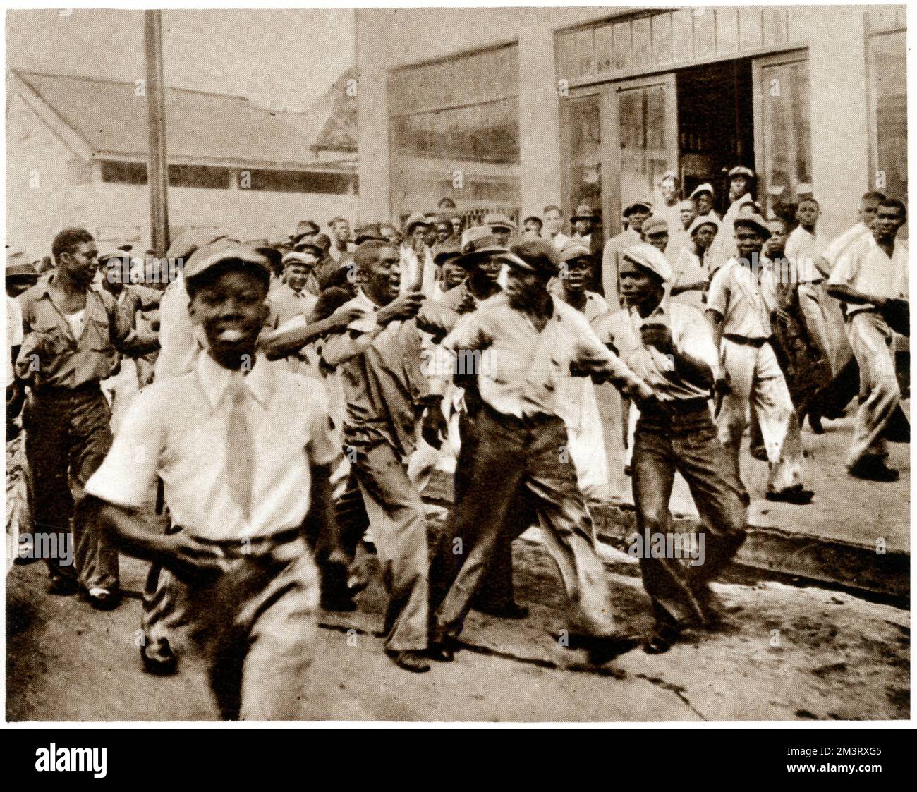 Riots in Jamaica in 1938 over a pay dispute.  Photograph shows a suspected blackleg, accused of intended strike-breaking in the docks,  being man-handled by other workers.     Date: 1938 Stock Photo