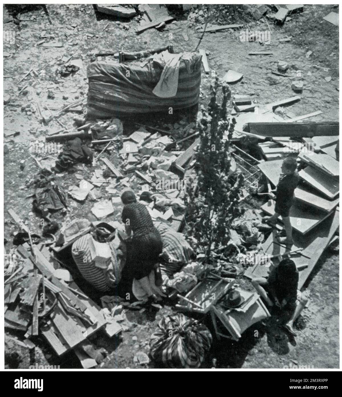 Mother searching for her belongings in debris 1939 Stock Photo