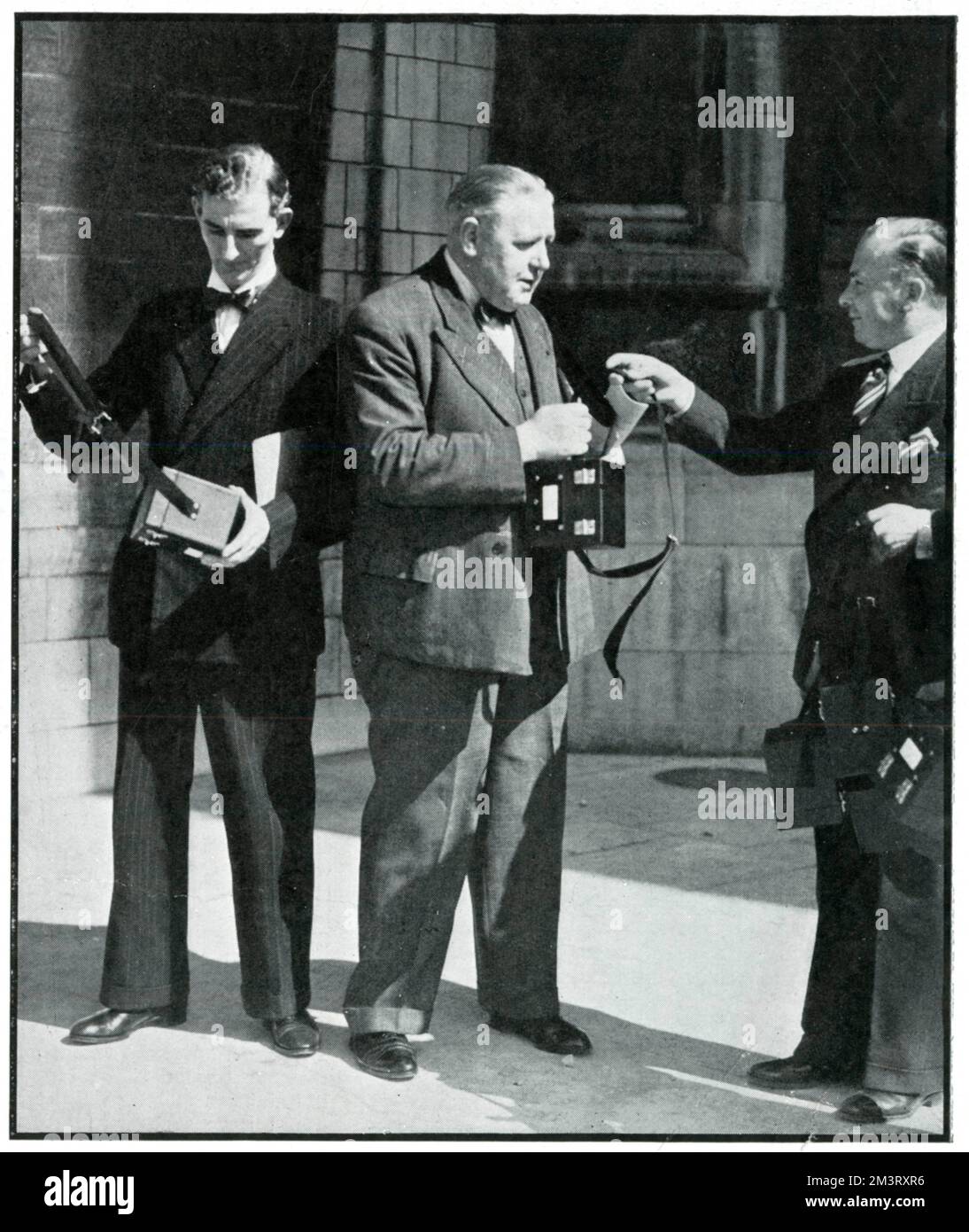 Mr Hutton, originally from Poland, photographed handing gas mask containers to Members of Parliament. The Sphere describes how Mr Hutton provided individually named gas mask containers for each representative as a gesture of thanks for British support in Poland against the German invasion, September 1939.  September 1939 Stock Photo