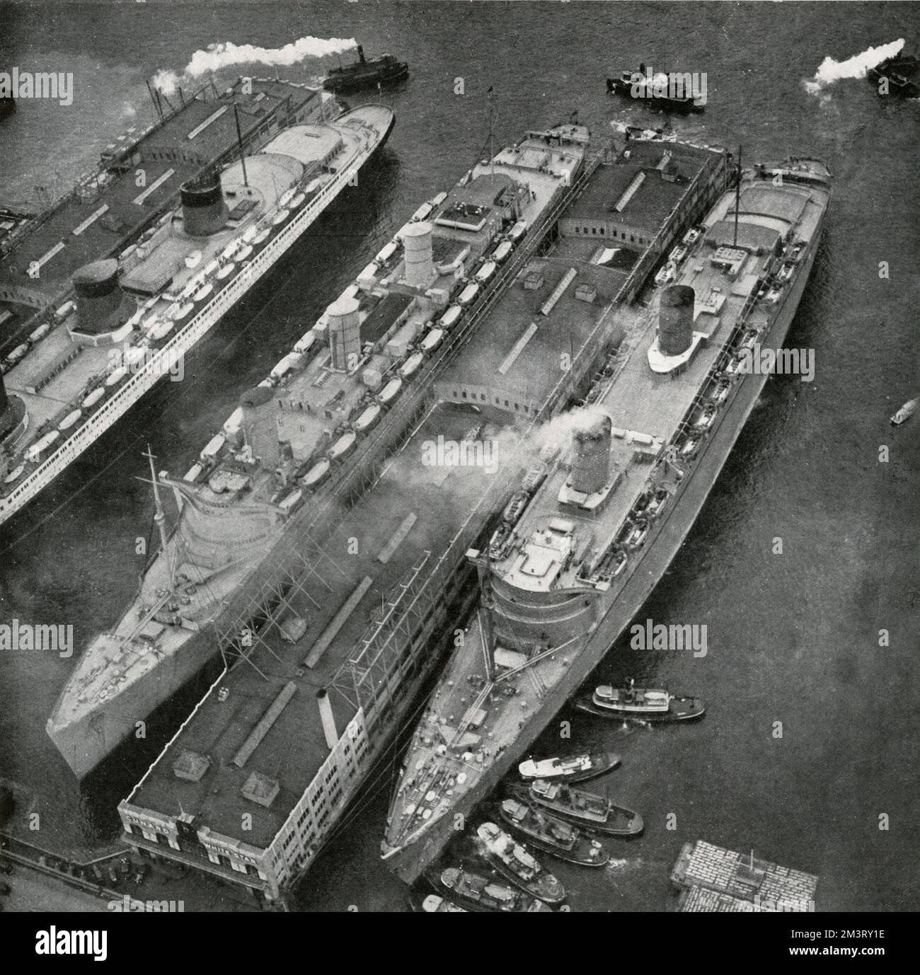 The Queen Elizabeth, SS Normandie and Queen Mary - the three fastest liners in the world - alongside each other in dock at New York Harbour - March 1940.  1940 Stock Photo