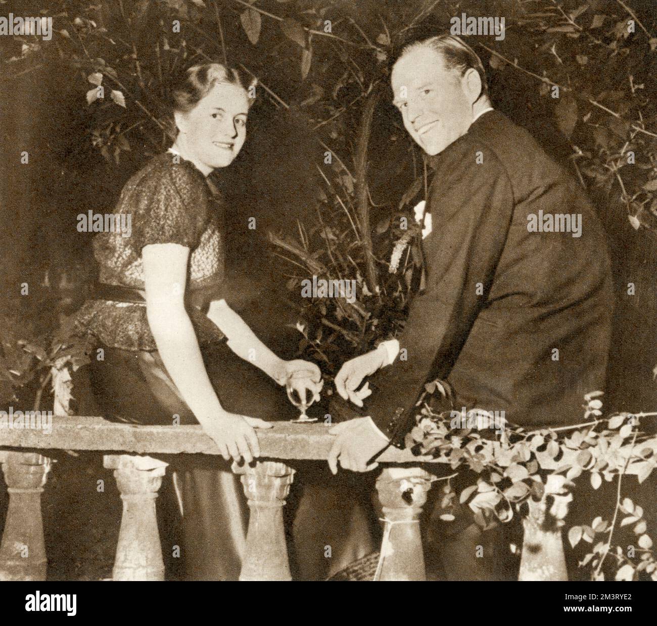 Mr Lanning Roper ()  - and Miss Shirley Cokayne-Frith having a chat after supper on the terrace at the coming out party given by Mrs. Tom Mott for her daughter Miranda at Park House, Onslow Square.     Date: 1952 Stock Photo