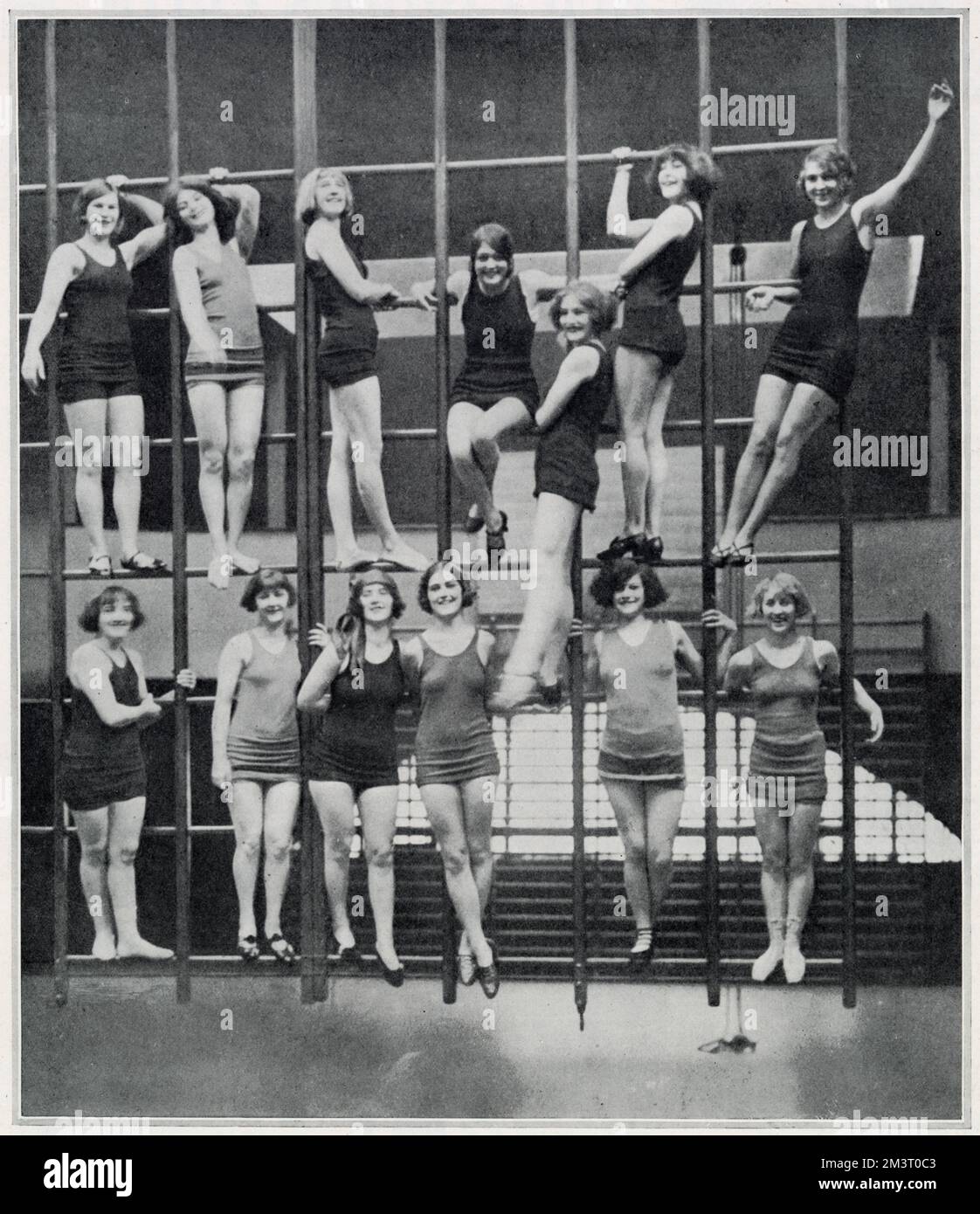 The Hoffman Girls, the dance troupe founded, managed and choreographed by Gertrude Hoffman, pictured in rehearsals for Leap Year which had had a successful run at the London Hippodrome and was moving on to the Palace Theatre in Manchester. As the original Leap Year dancers had been contracted to give a show at the Folies Bergere in Paris, Hoffman recruited a new set for the Manchester revue. They are pictured here in the gymnasium practising for part of their act which required them to climb and hang from webbing.     Date: 1925 Stock Photo