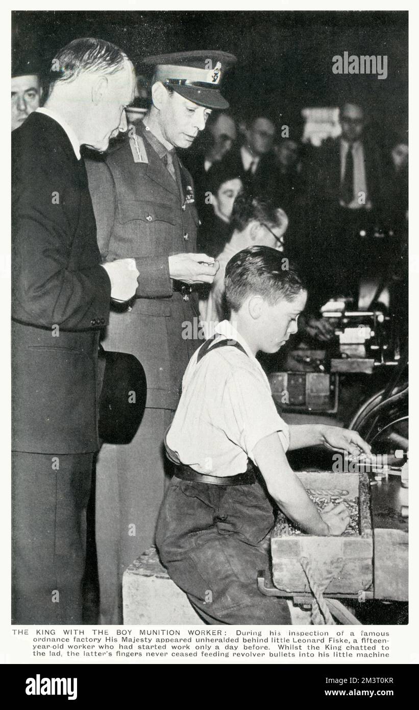 WW2 - Home Front - King George VI meets a young boy munition worker (15 year-old Leonard Fiske) during his inspection of a famous munitions factory - the lad continued to feed revolver bullets into his machine throughout his chat to the monarch. Stock Photo