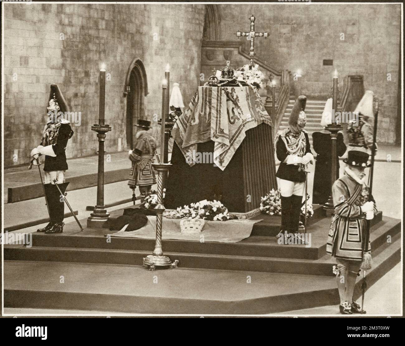 Over 5000 people an hour passed through Westminster Hall to pay their tributes to the late King George VI during his ceremonial lying-in-state with Officers of the Life Guards of the Husehold Cavaly standing motionless at the corners of the catafalque, with Yeoman Warders on the step below.     Date: 1952 Stock Photo