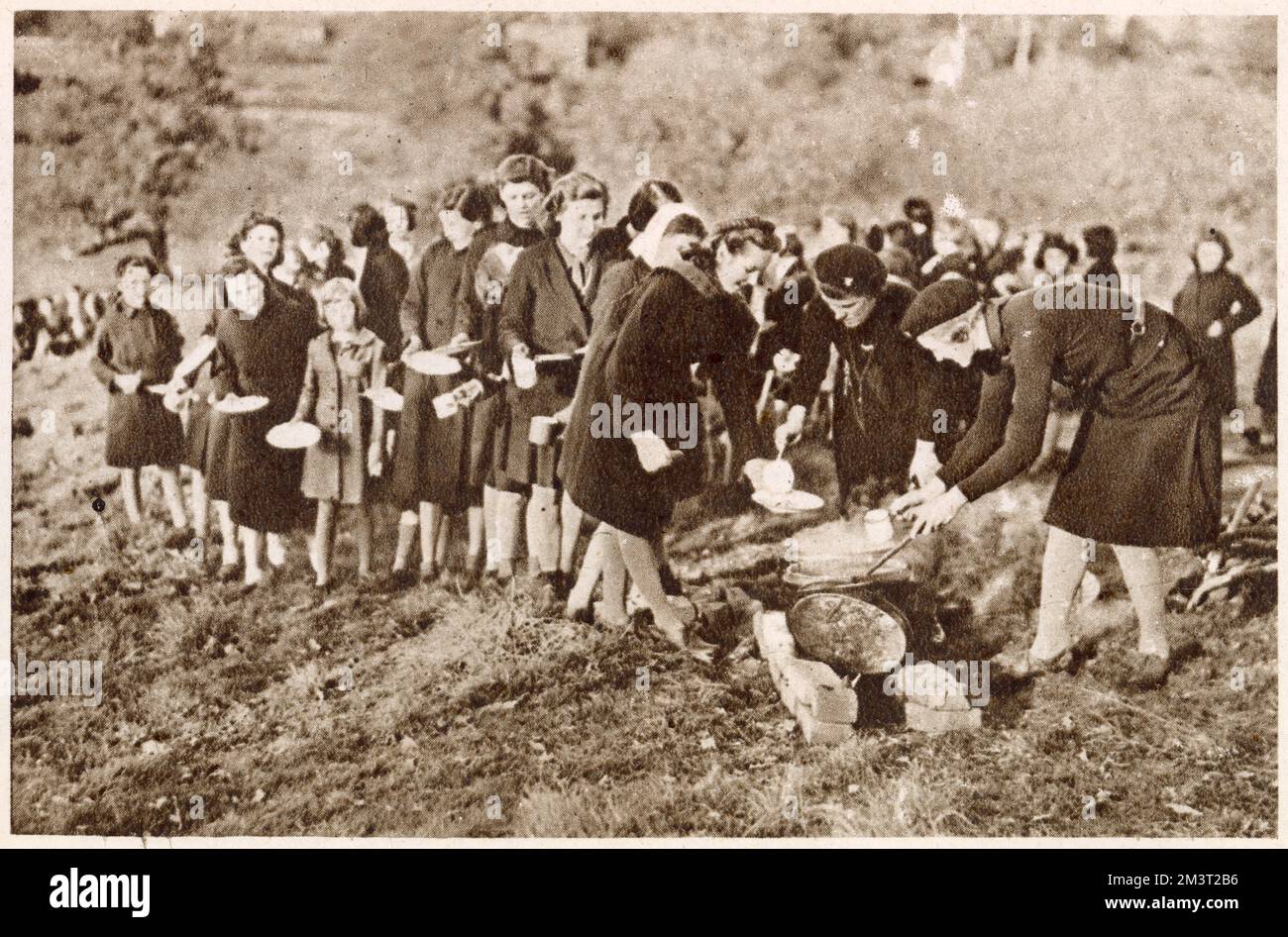 Members of the Guide International Service, rehearsing mass food preparation and serving in the open air. The Guide International Service provided volunteers to work in relief camps in Europe during the Second World War. Stock Photo