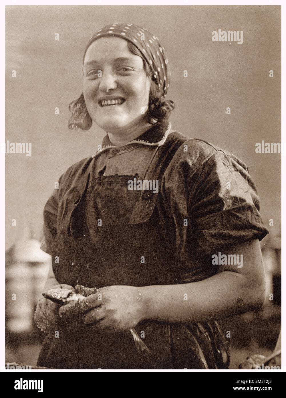 One of the 3,000 Scottish women that came every year to Great Yarmouth in the herring harvest to gut fish in the months of October and November.      Date: October 1932 Stock Photo