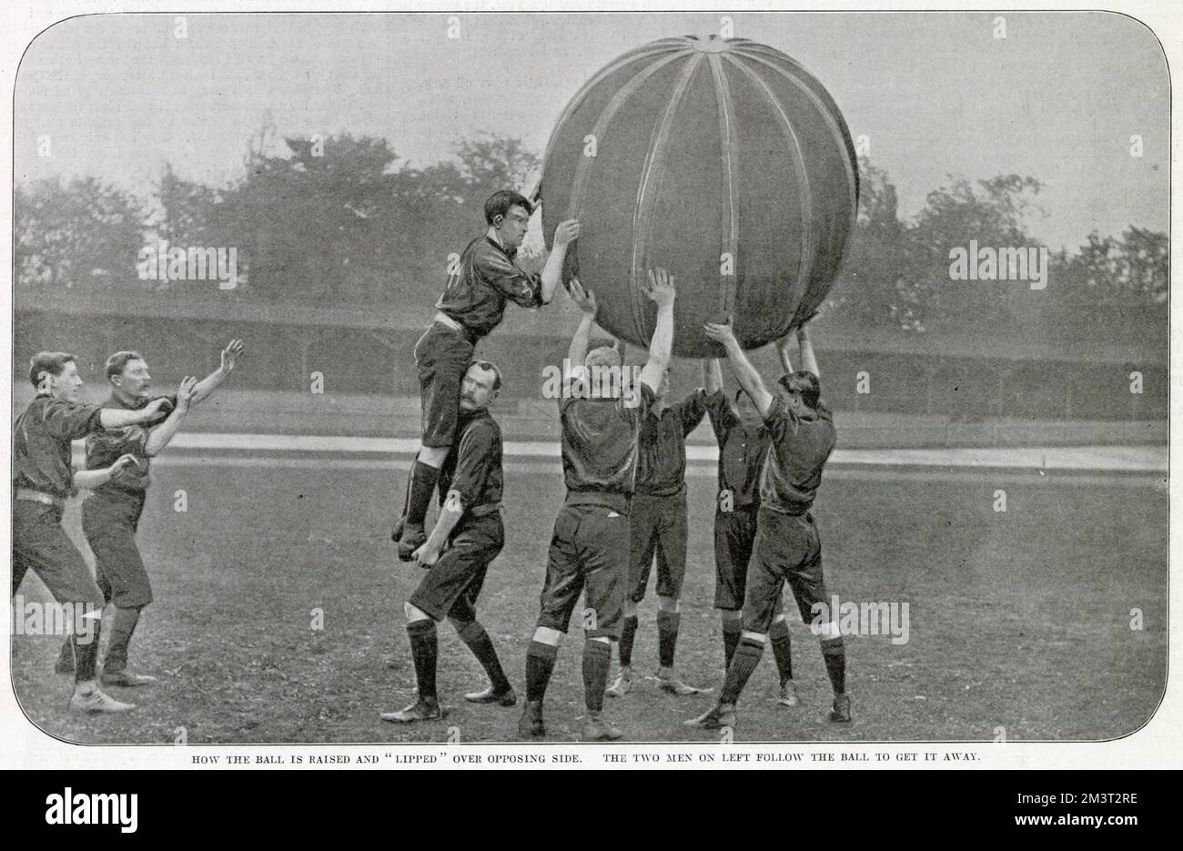 A game of 'pushball' between Anerley and Crystal Palace at the Crystal Palace sports ground. This match, one of the first played in Britain of this American game, was won by Anerley by 1 goal and 3 tries. Photograph showing the ball raised and 'lipped' over opposing side, the two men on the left follow the ball to get it away. Stock Photo
