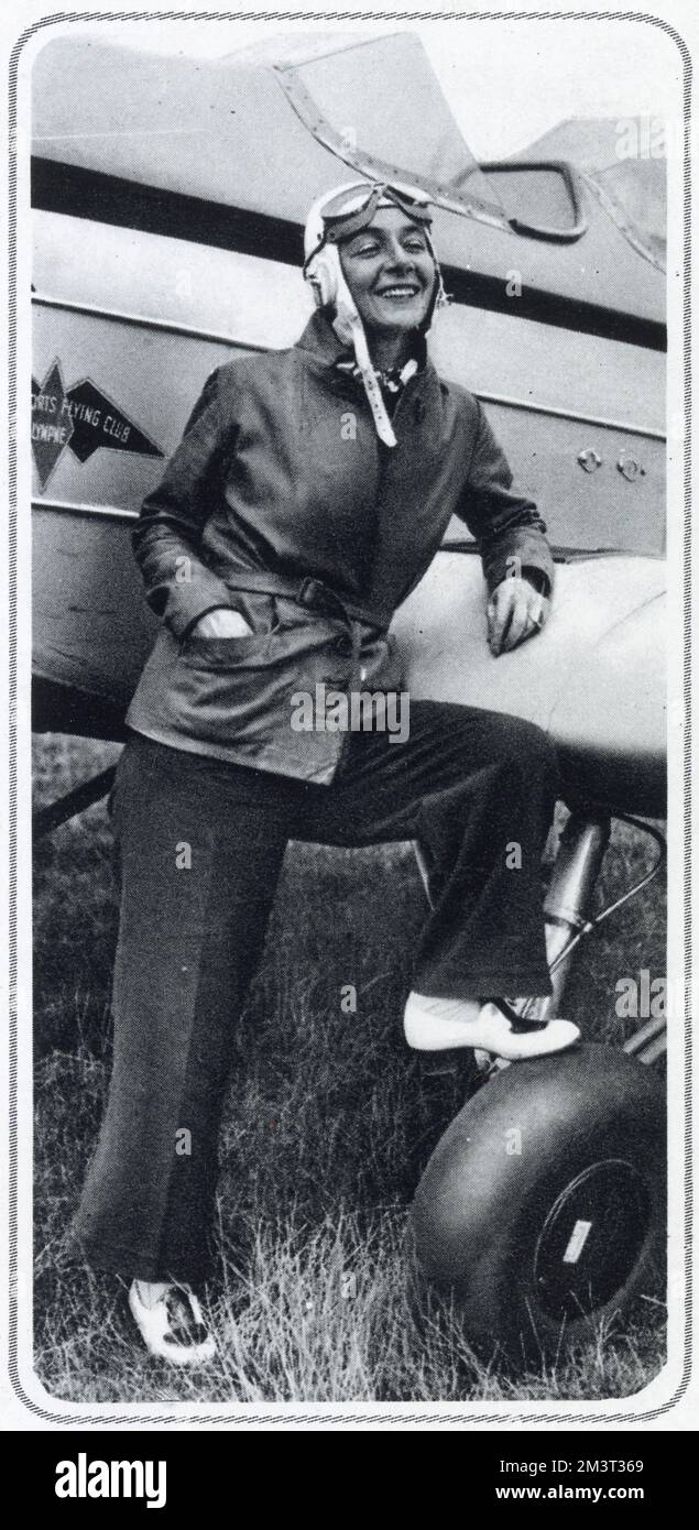 Gladys Edith Mabel Calthrop (née Treeby), (1894 - 1980), artist and leading British stage designer. She is best known as the set and costume designer and for her collaborations, providing set and costumes for her friend Noel Coward's plays. Gladys was also a keen aviator and is pictured here posing by a plane at the Cinque Ports Flying Club, Lympe - Noel Coward was Vice President of the club. Stock Photo