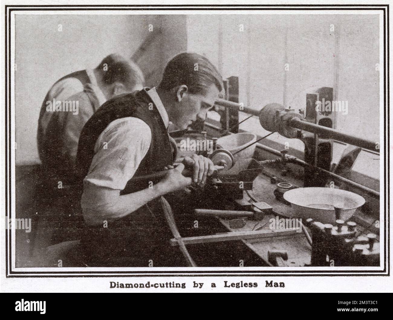 A legless ex-soldier using diamond-cutter machine. A pilot scheme was started in spring 1917 by Mr. Bernard Oppenheimer, a diamond merchant. The factory provided training for thousands of wounded ex-soldiers and sailors during and after World War One. Stock Photo