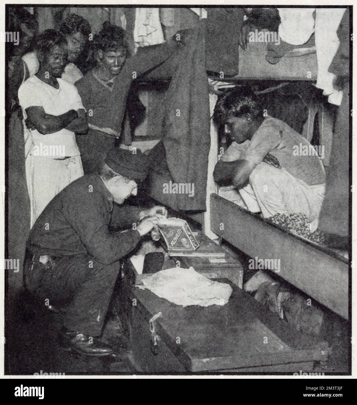 A customs official from the 'flying squad' searches the quarters of a Lascar crew of a sugar freighter to check no dutiable goods have been hidden in odd corners. Stock Photo