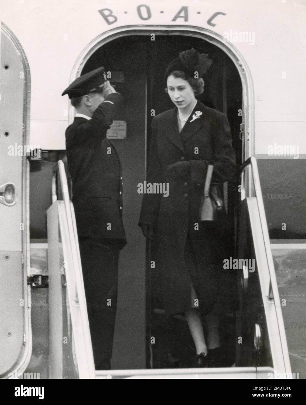 Arriving back from a tour of the Commonwealth in Kenya, Queen Elizabeth II wearing black steps from the plane, after the death of her father George VI.      Date:  7th February 1952 Stock Photo