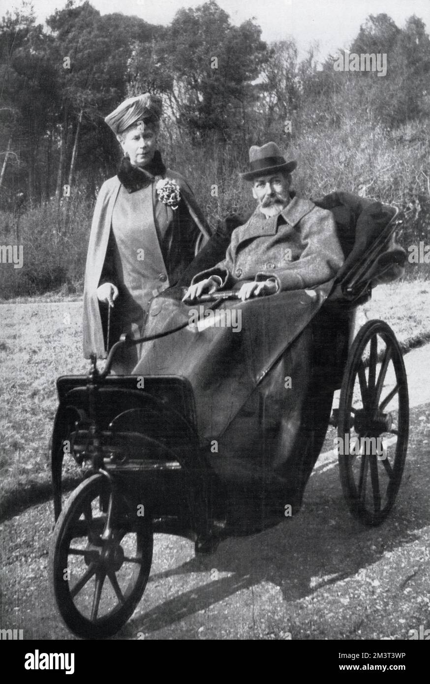 King George V (1865-1936) with Queen Mary in a bath chair (made 40 years previously for Queen Victoria) enjoying the Spring sunshine at Craigwell House, Bognor Regis, West Sussex. Stock Photo