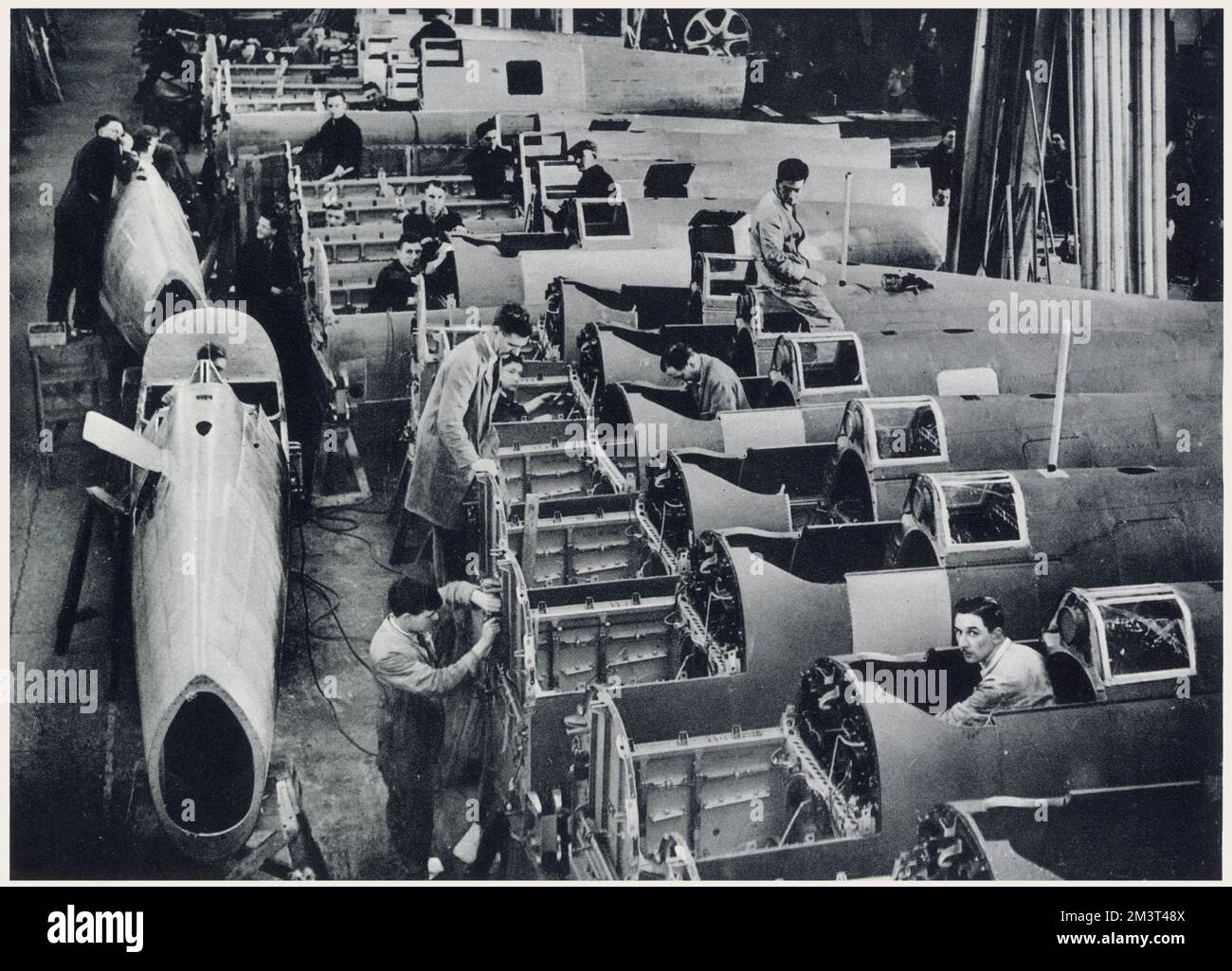 Mass production day and night of the single-seater fighter Spitfire at Vickers-Supermarine works, Southampton, Britain. Photograph showing the manufacture of the centre sections of the Spitfire fuselages, which is built in three parts, receiving their finishing touches after leaving the cradles.      Date: February 1939 Stock Photo