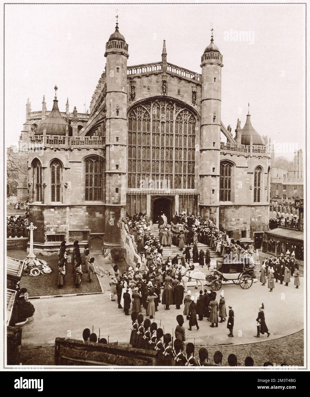The coffin of King George V borne up the steps by Guardsmen of the King's Company, Grenadier Guards, to the West Door of St. George's Chapel. Following the coffin are King Edward VIII, his mother, Queen Mary, the Princess Royal and the late King's sister, Queen Maud of Norway. Stock Photo