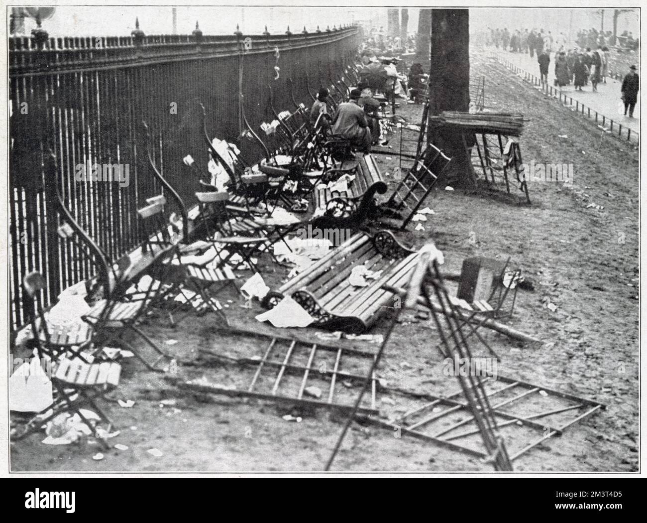 Newspapers, broken chairs, seats and railings left in Green Park after crowds had dispersed following the funeral procession of King George V through London. Stock Photo