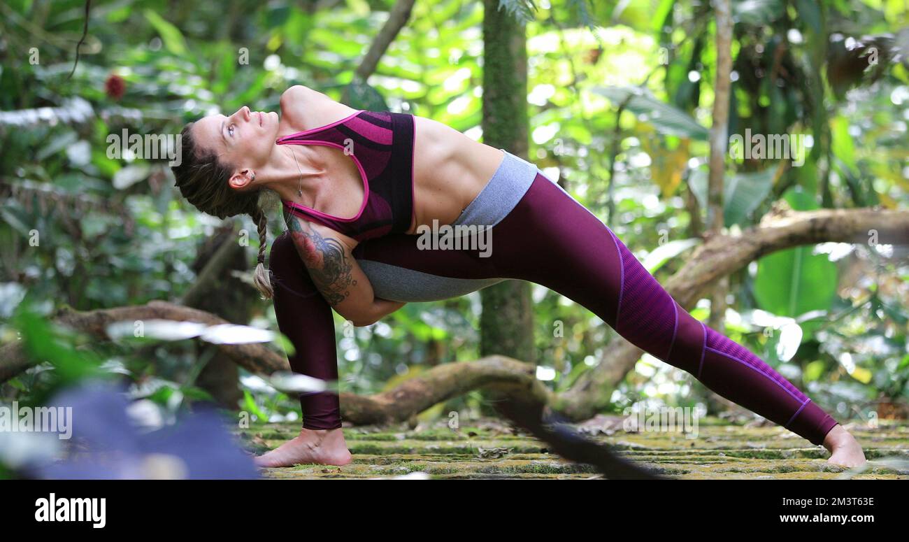 Woman training Yoga pose outdoors in nature Stock Photo