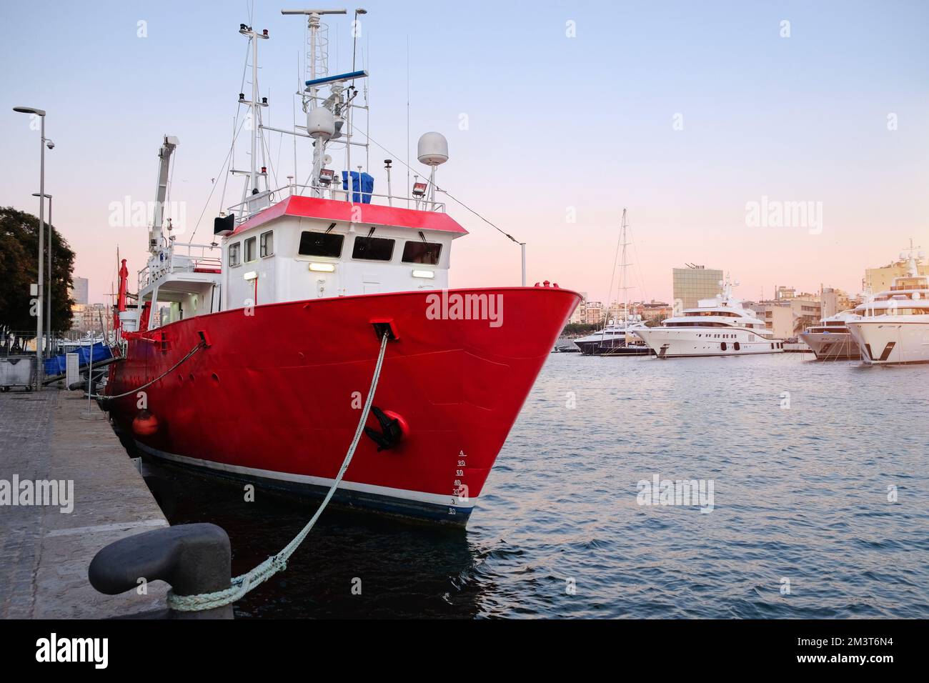 Tugboat at the harbor pier, cargo seaport. Boats and cranes Stock Photo