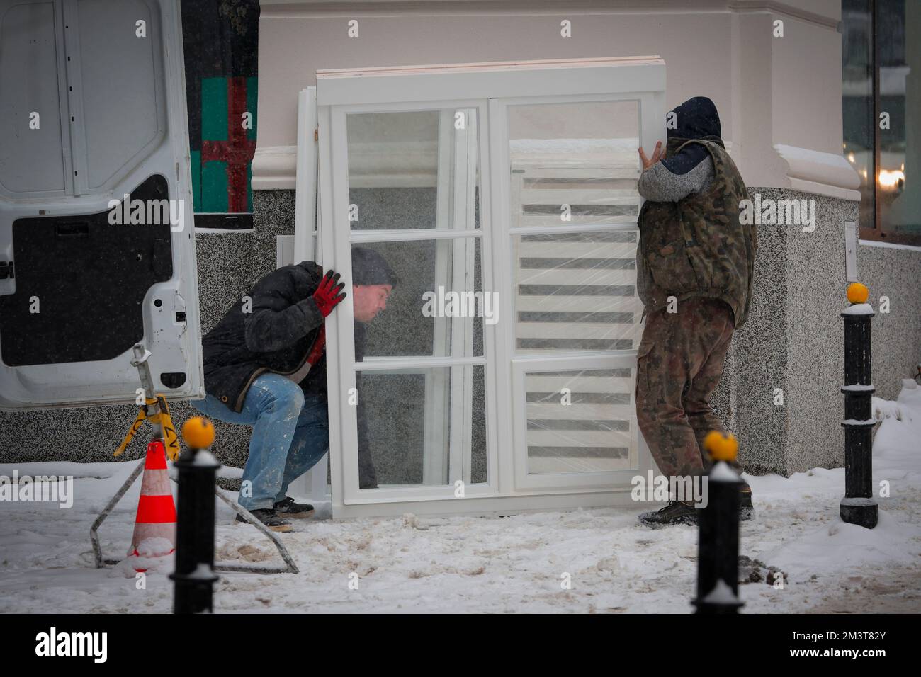 Warsaw, Poland. 16th Dec, 2022. Men carry a window pane in Warsaw, Poland on 16 December, 2022. Poland sees heavy snowfall for the sixth consequetive day with nightly temperatures in some ares of the country falling to nearly minus 20 degrees Centigrade. (Photo by Jaap Arriens/Sipa USA) Credit: Sipa USA/Alamy Live News Stock Photo
