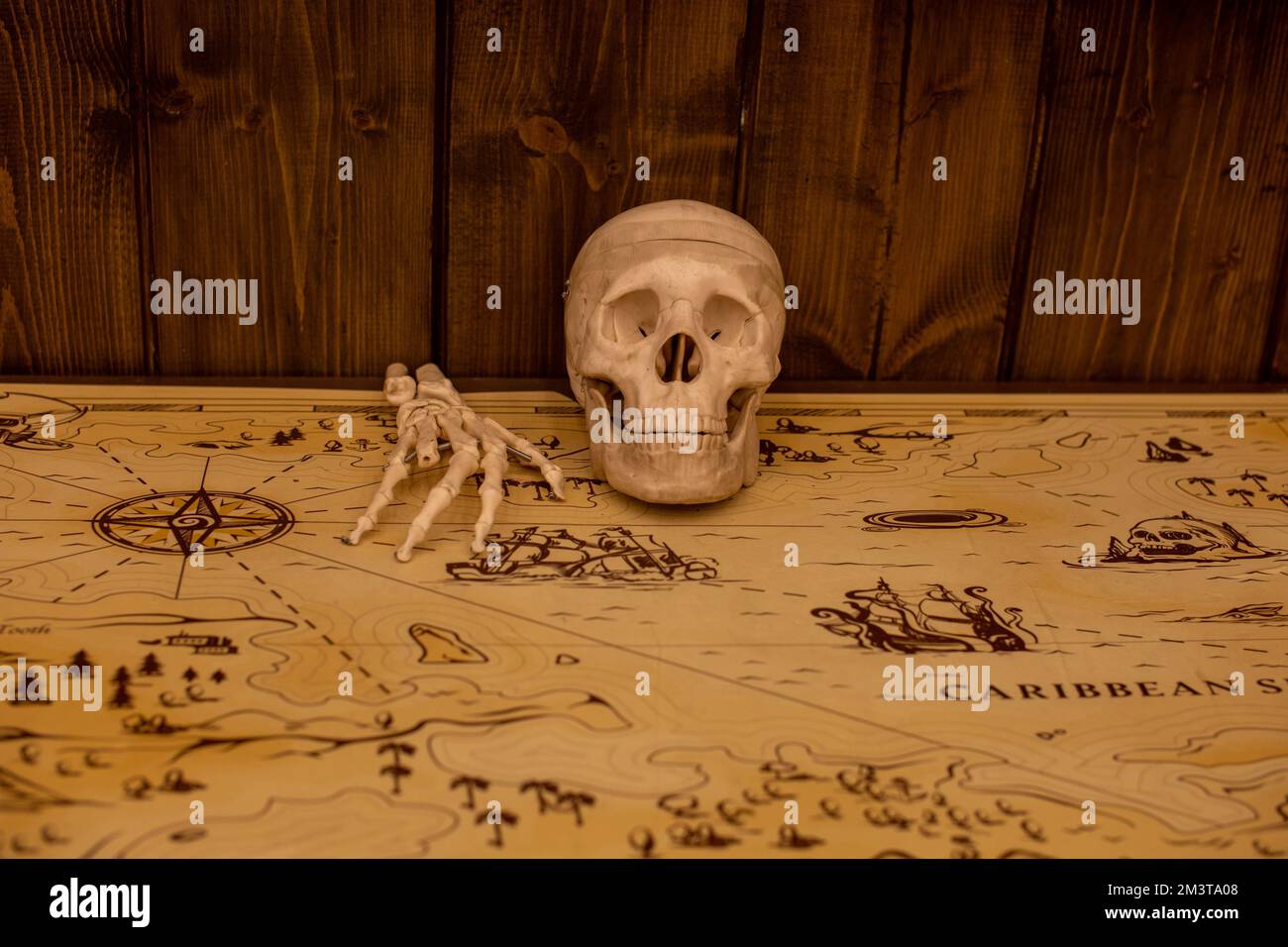 A skull and bones of a hand on the pirate's map Stock Photo - Alamy