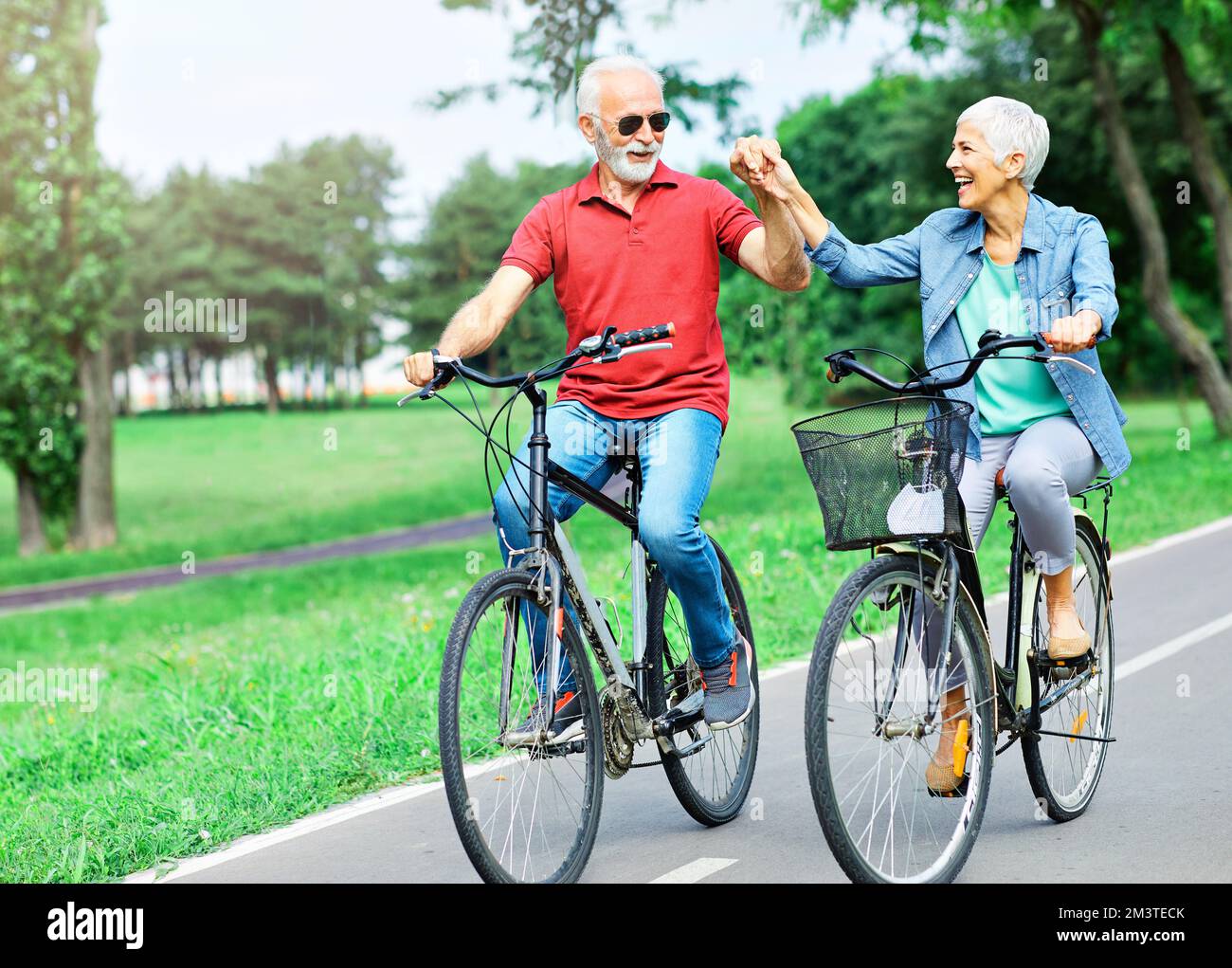 Elderly laughing woman riding bike hi res stock photography and