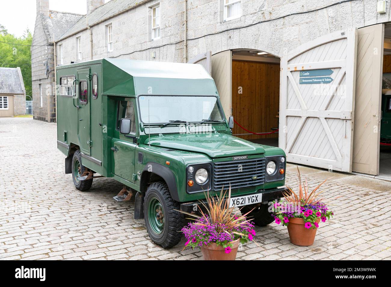Balmoral Castle grounds and green modified Land Rover Defender part of the Queen Elizabeth 11 fleet of cars vehicles Stock Photo