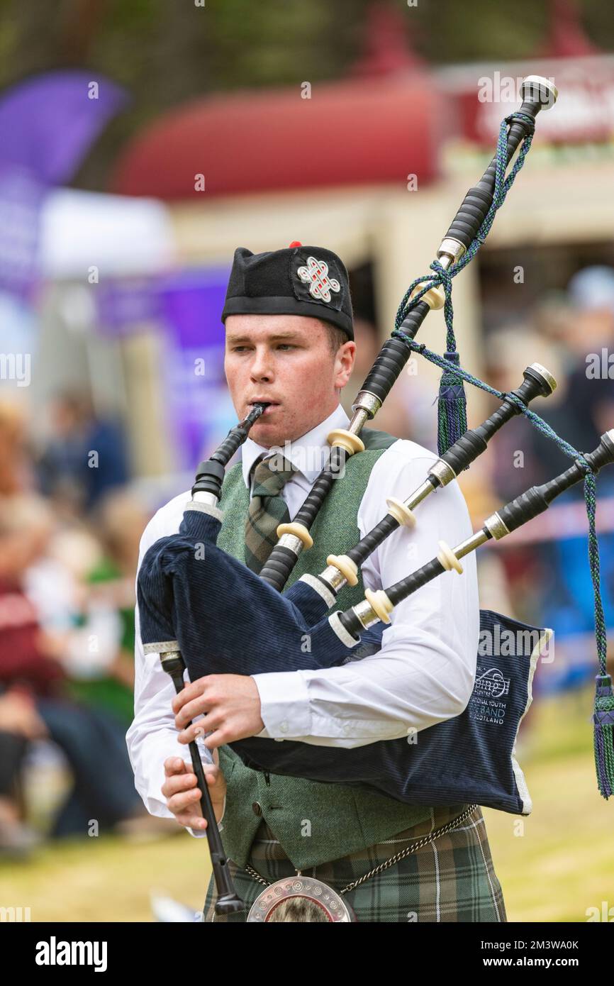 Young man playing the bagpipes at Tomintoul Highland Games in Scotland summer 2022, judges assessed each competitors performance Stock Photo