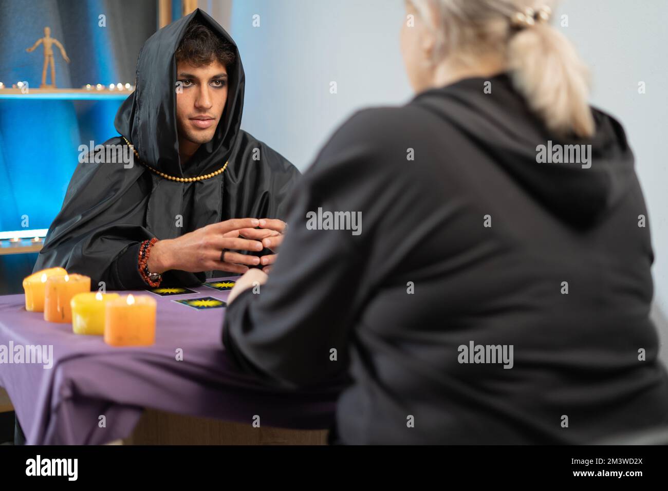 Tarot cards. fortune teller man holding a pack of tarot cards while shuffling them. Mystical session with client Stock Photo