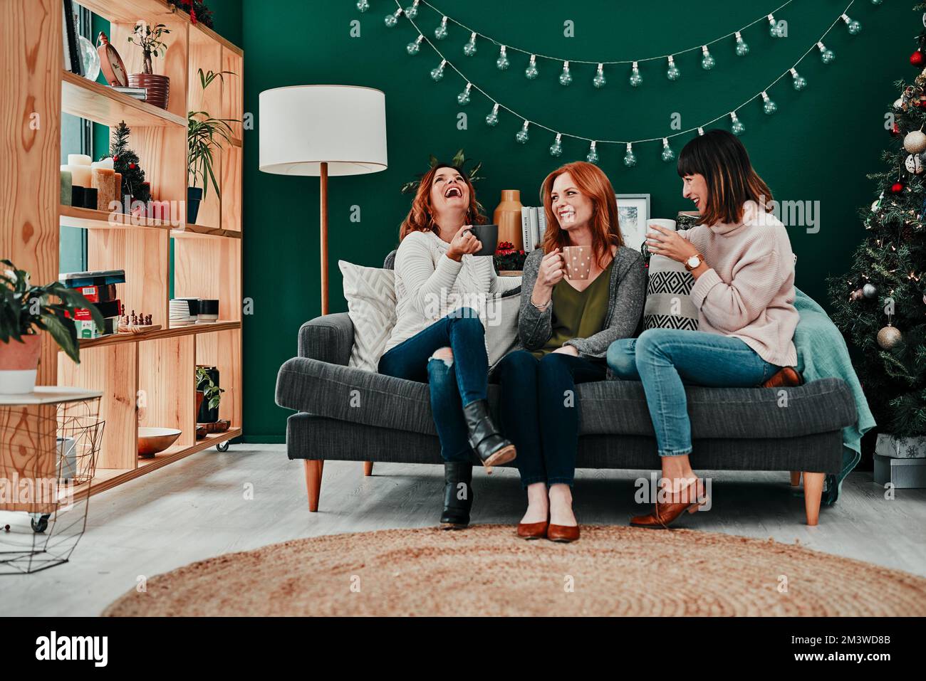 Coffee date with my girls. three attractive middle aged women having coffee together during Christmas eve at home. Stock Photo