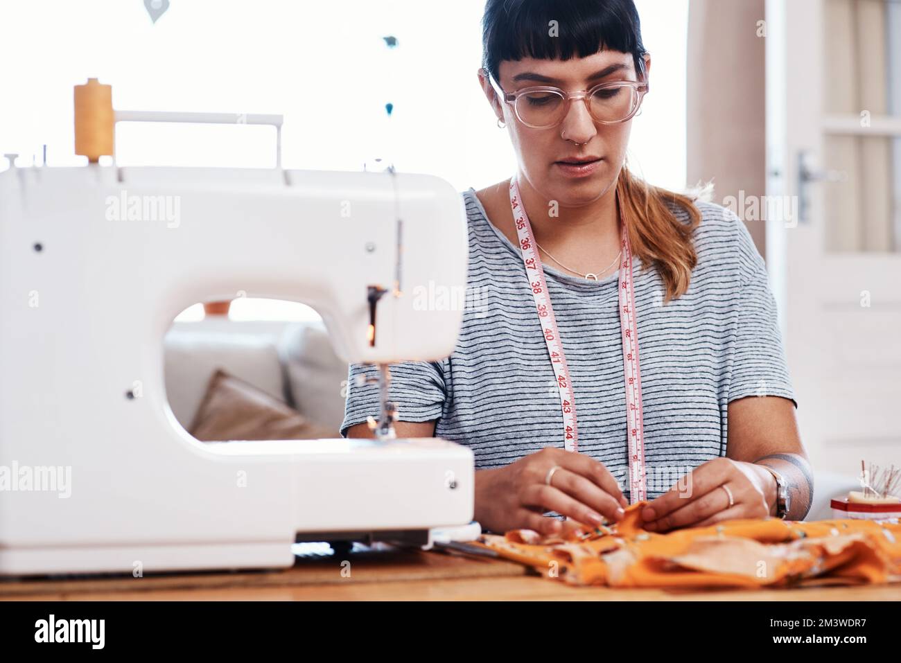Focused on perfect every detail. a young woman designing a garment at home. Stock Photo