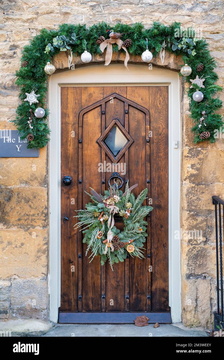 Christmas wreath on a stone cottage door. Stow on the Wold, Cotswolds, Gloucestershire, England Stock Photo