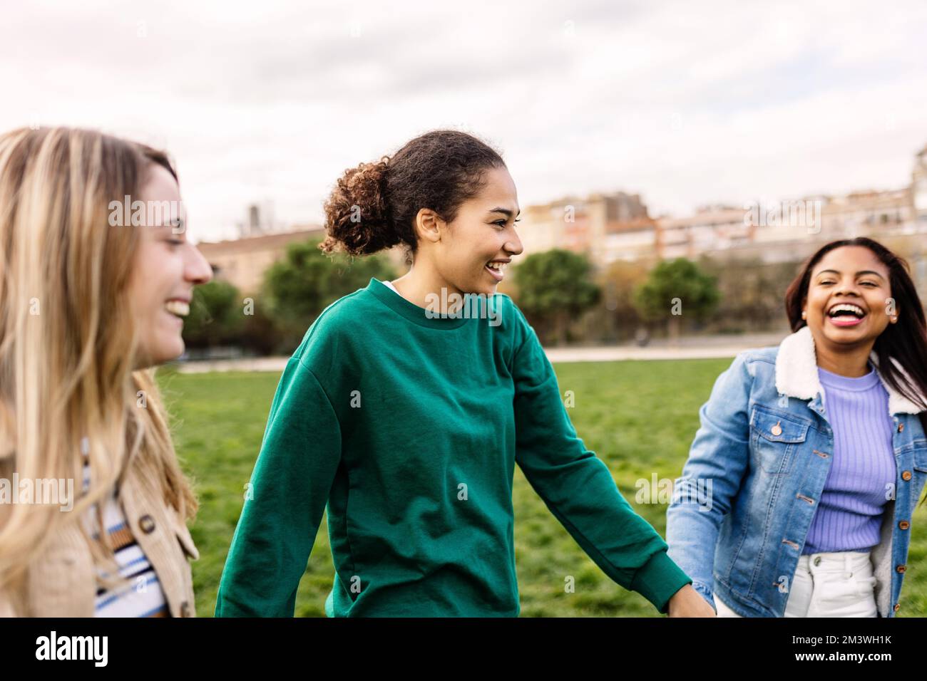 Muslim young woman having fun with diverse female friends outdoors Stock Photo