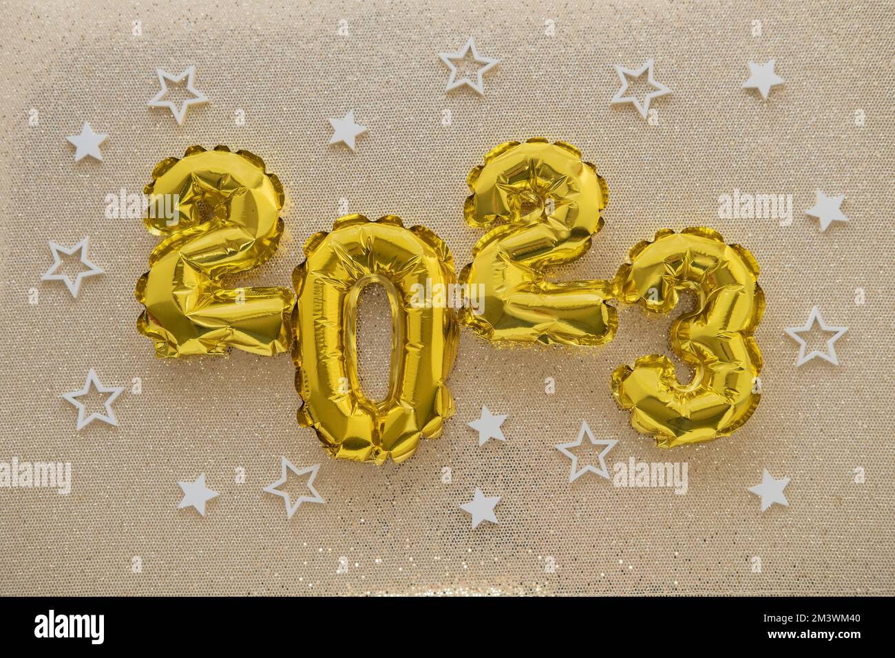 2023 gold foil balloons and confetti on gold glitter background. Festive concept. Stock Photo