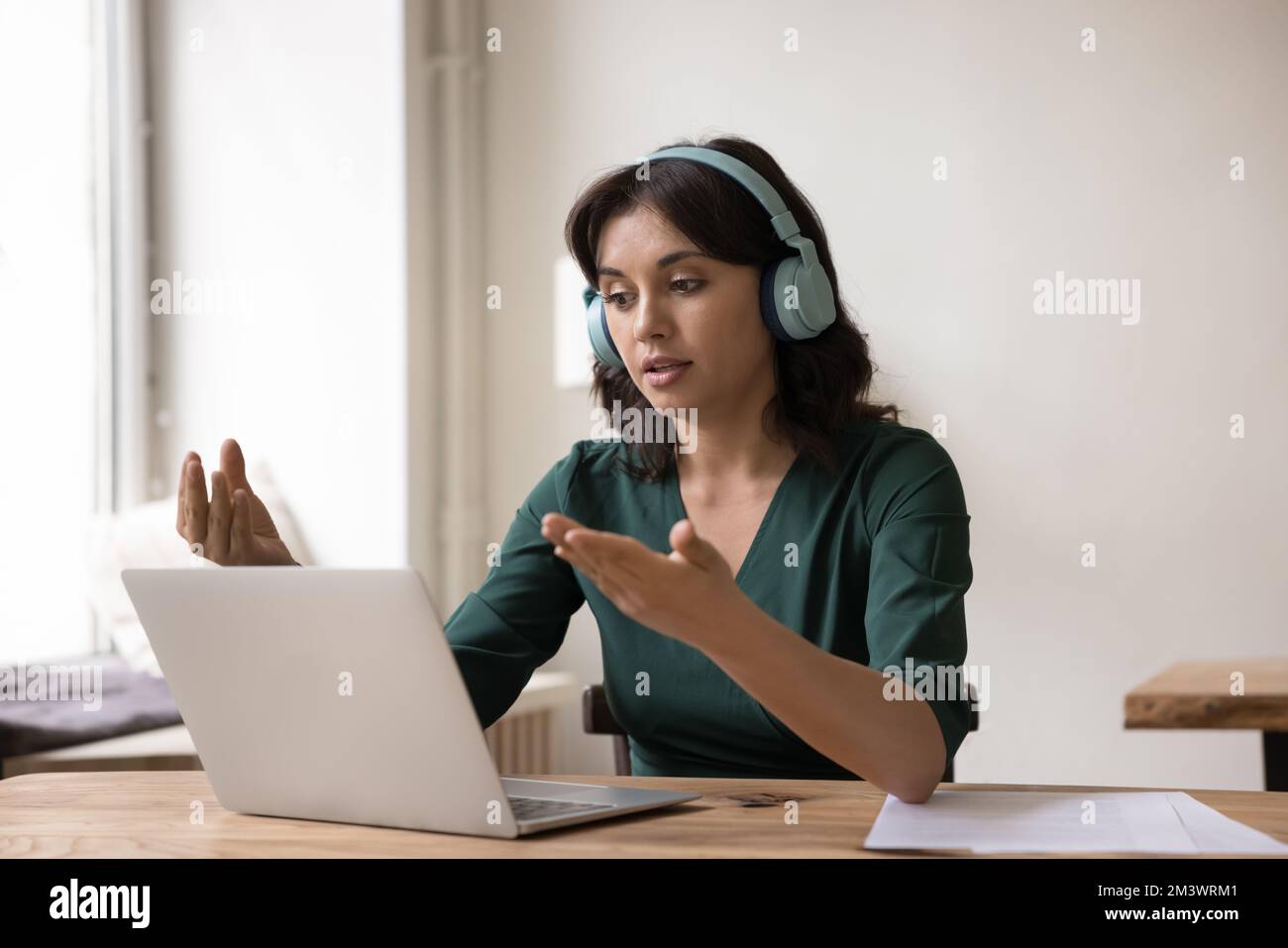 Engaged online teacher, coach giving workshop, webinar, using laptop Stock Photo