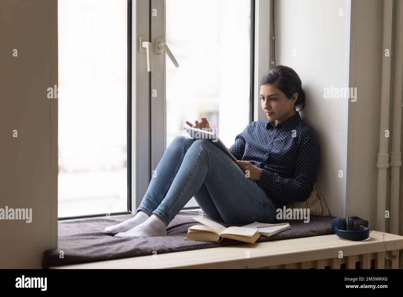 Serious busy pretty Indian student woman studying at home Stock Photo