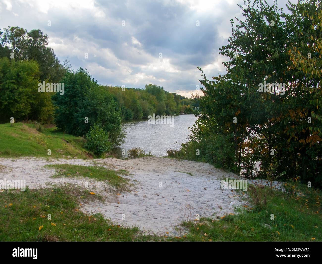 A beautiful shot of a lake surrounded by trees under a cloudy sky Stock ...