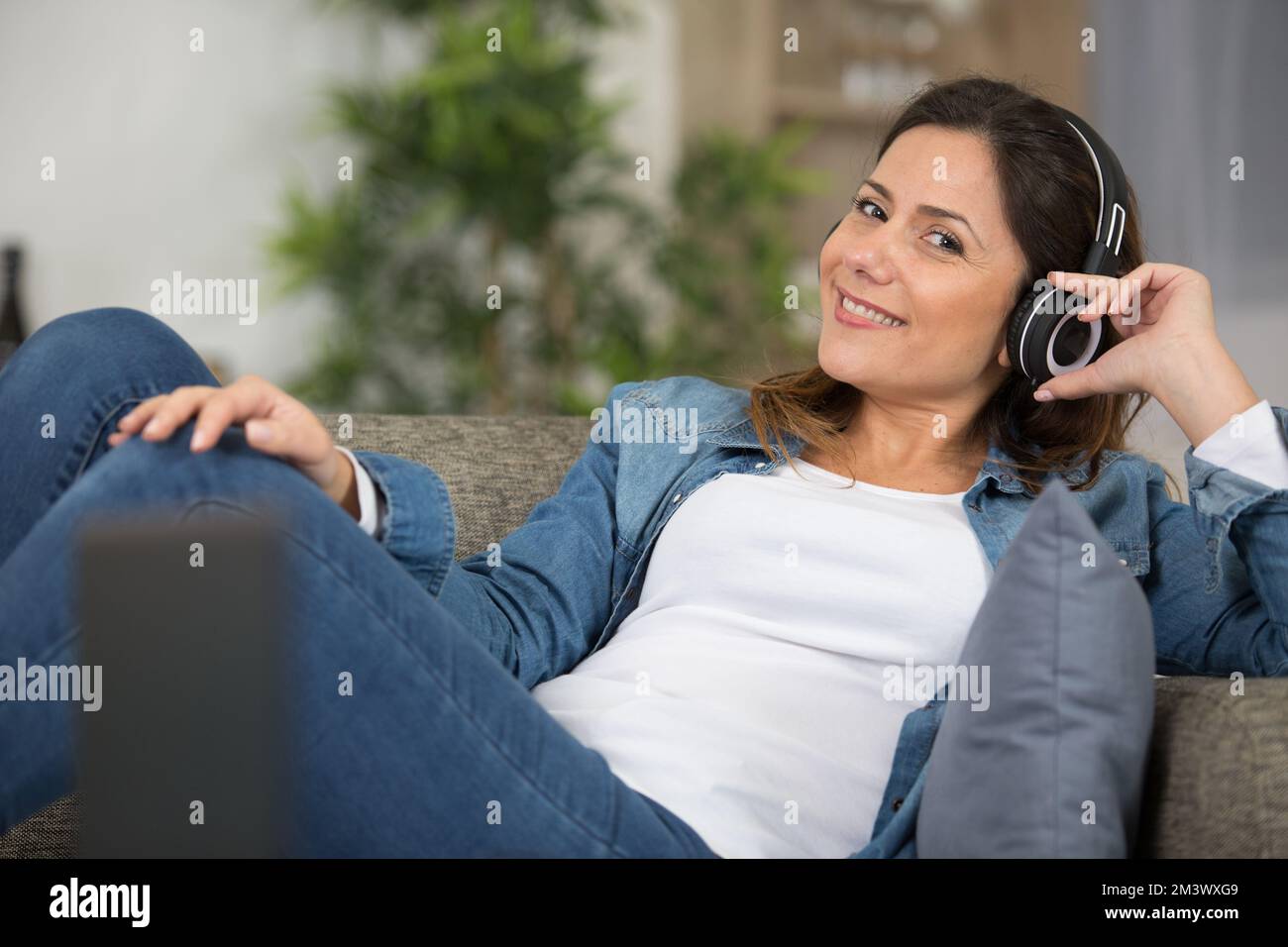 Woman lounging on sofa using hi-res stock photography and images - Alamy