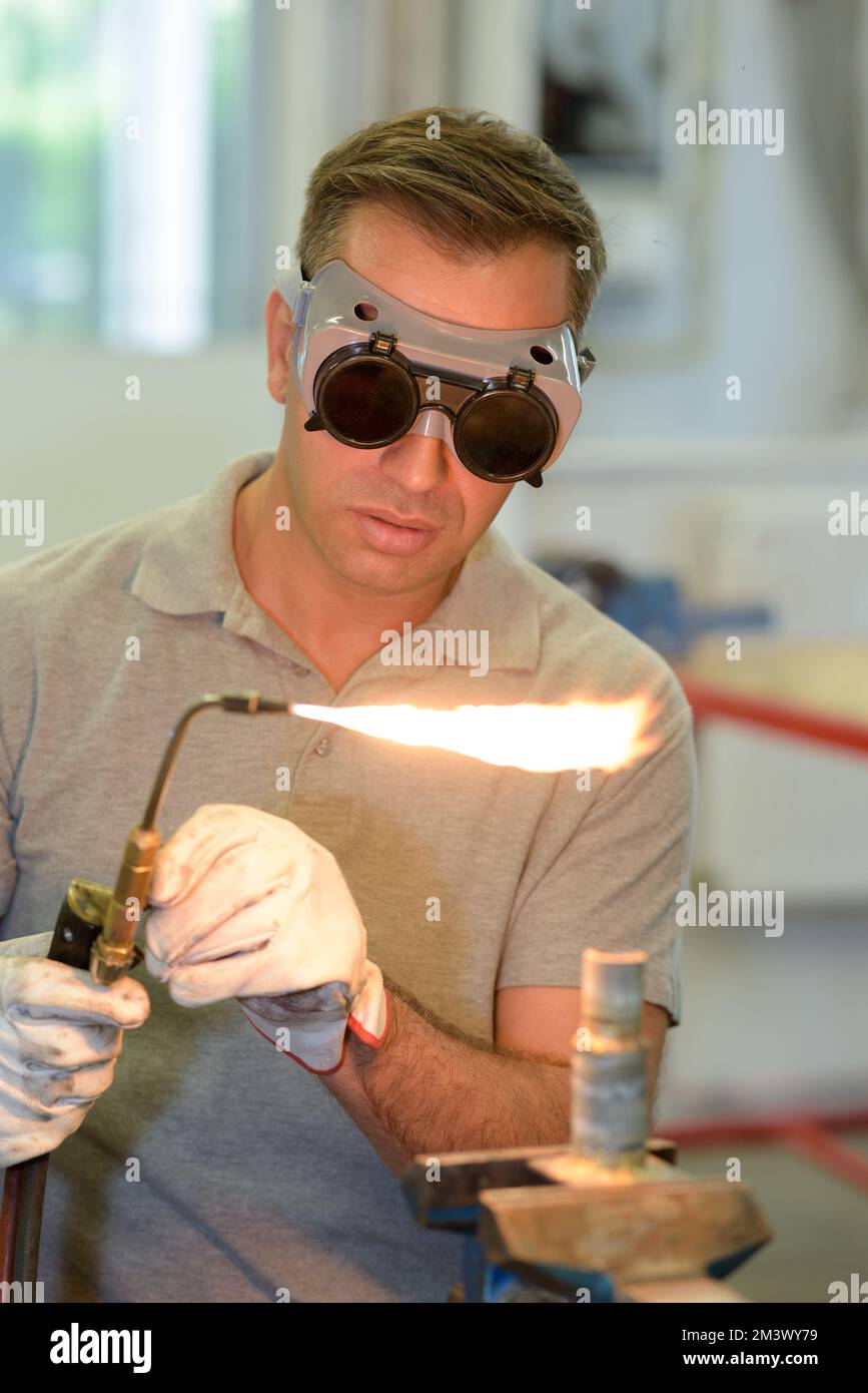 man wearing protective eyewear using gas torch Stock Photo