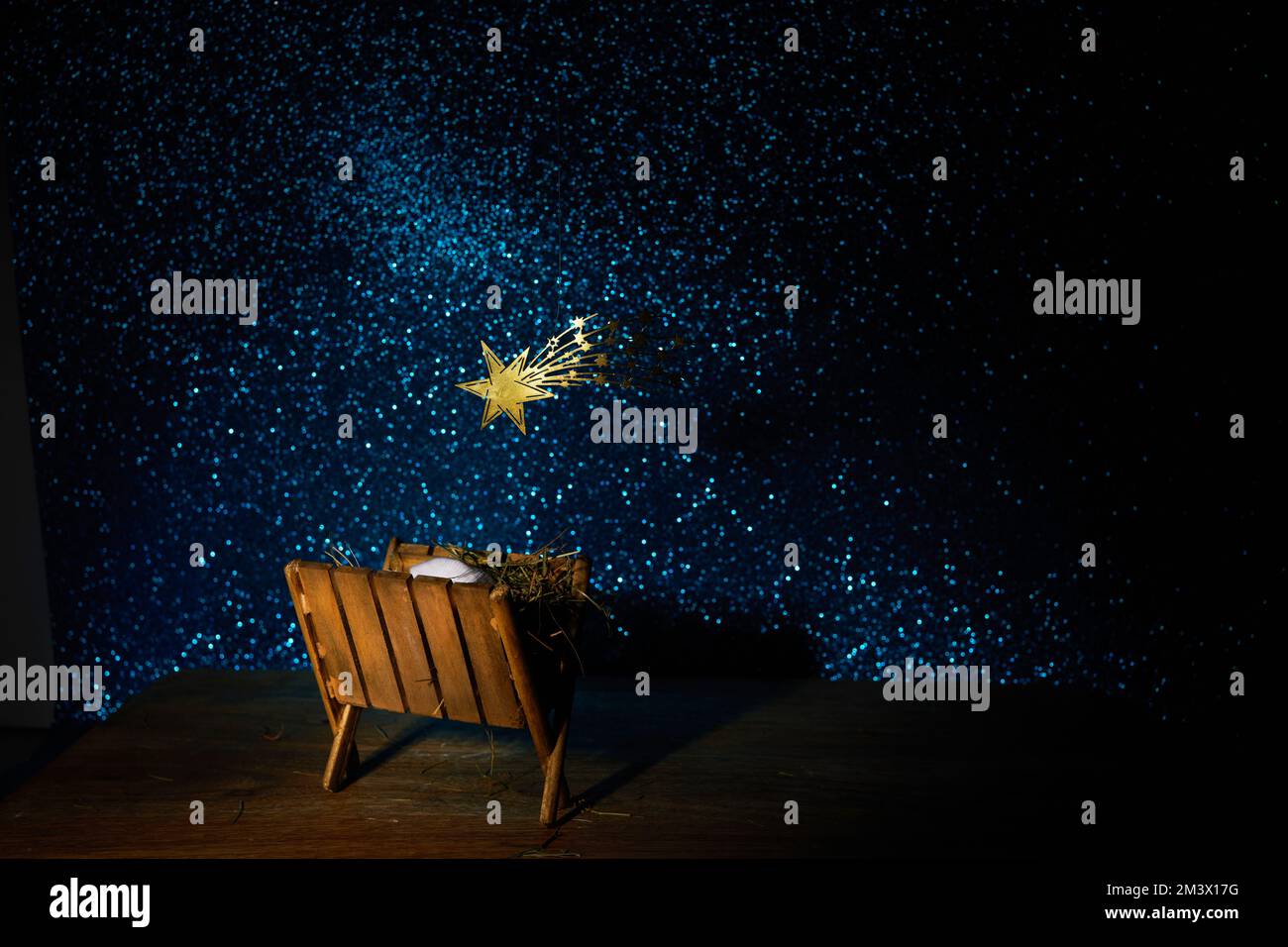 Nativity of Jesus, empty manger at night with bright lights Stock Photo
