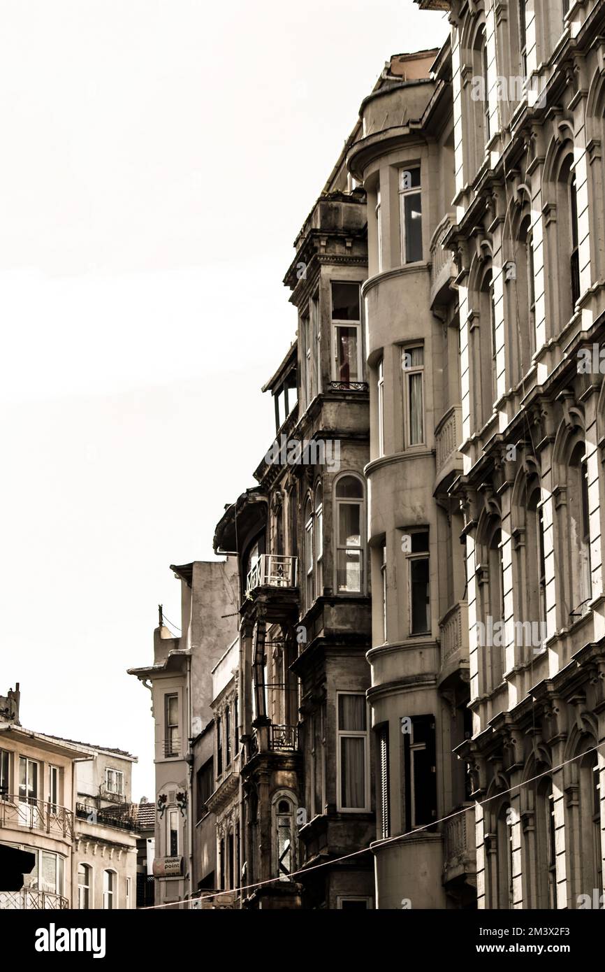 Historical stone houses and street view in Beyoğlu, Istanbul. Historic buildings, pale colors, white sky. Vertical photo. No people, nobody. Stock Photo
