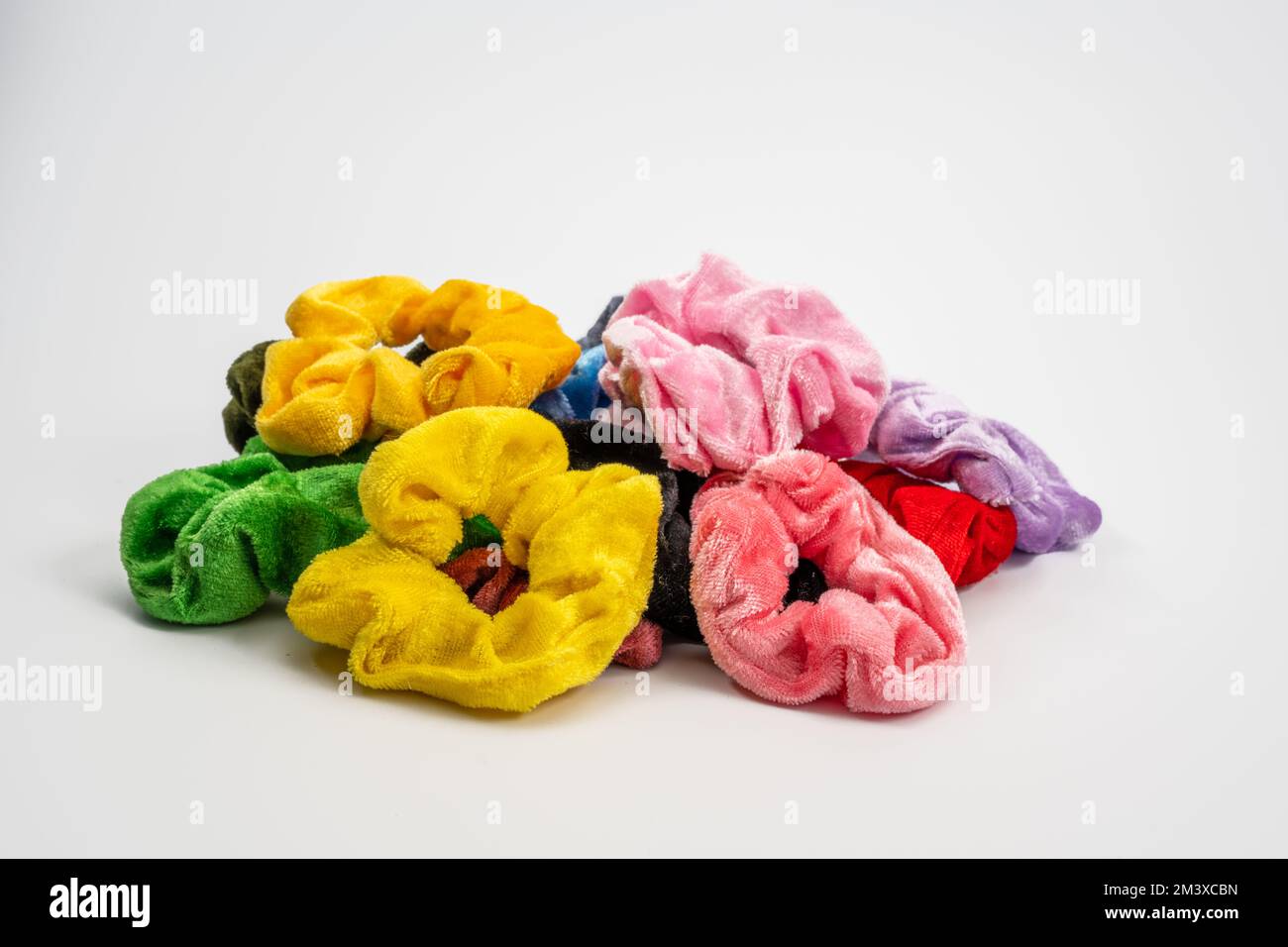 loose random assortment of  velvet hair scrunchies multi colored isolated on a white background Stock Photo
