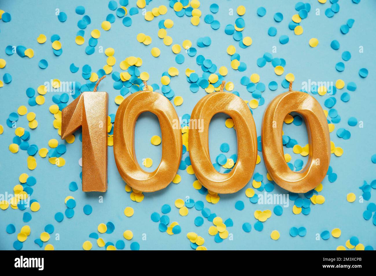1000 one thousand followers subscriber card golden birthday candle on yellow and blue confetti Background. Template for social networks, blogs. celebration banner. 1000 online community fans. Stock Photo