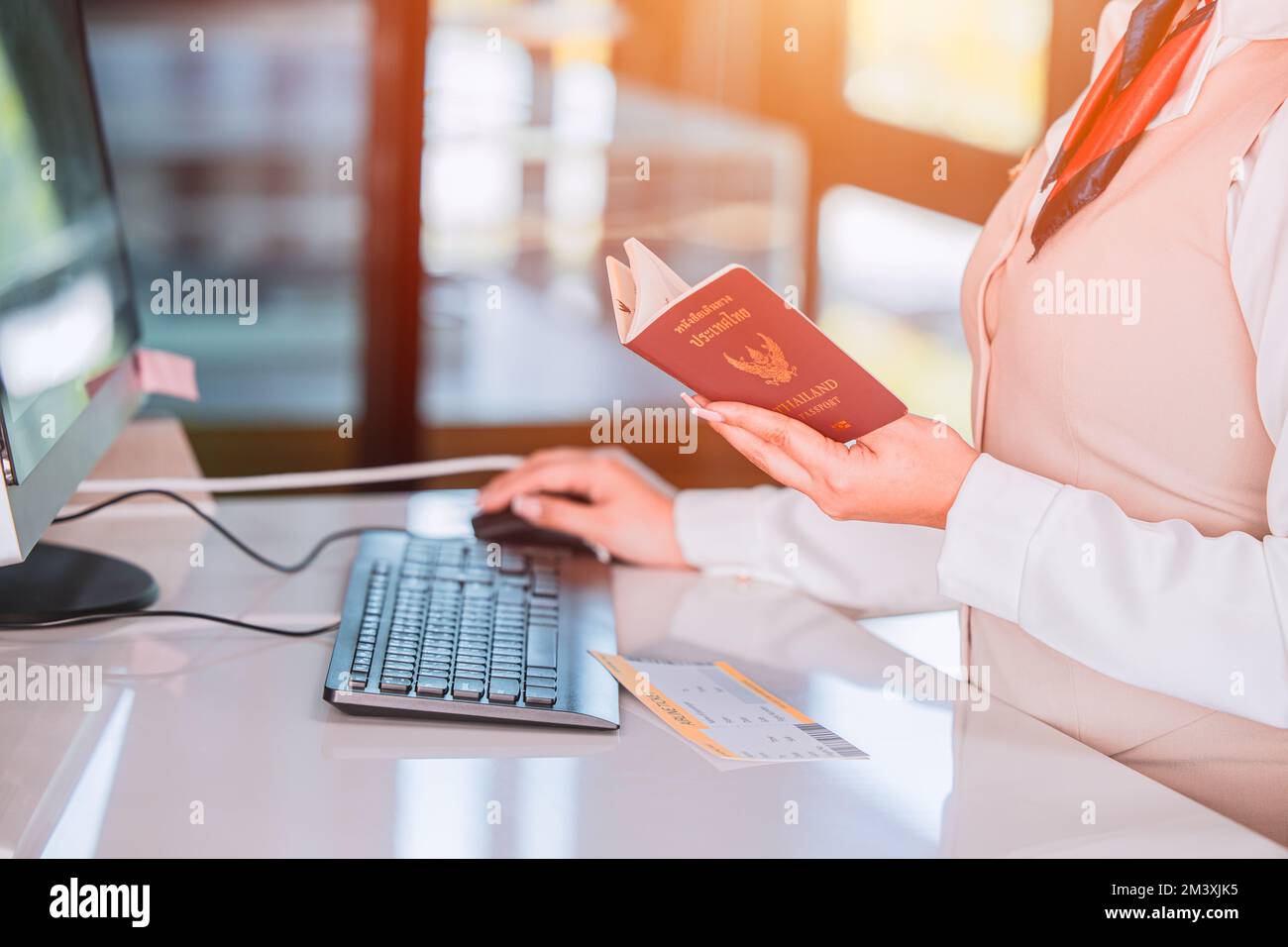 Thailand travel concept. Airline officer check in ticket Thai tourist with Passport Visa book at counter service Stock Photo