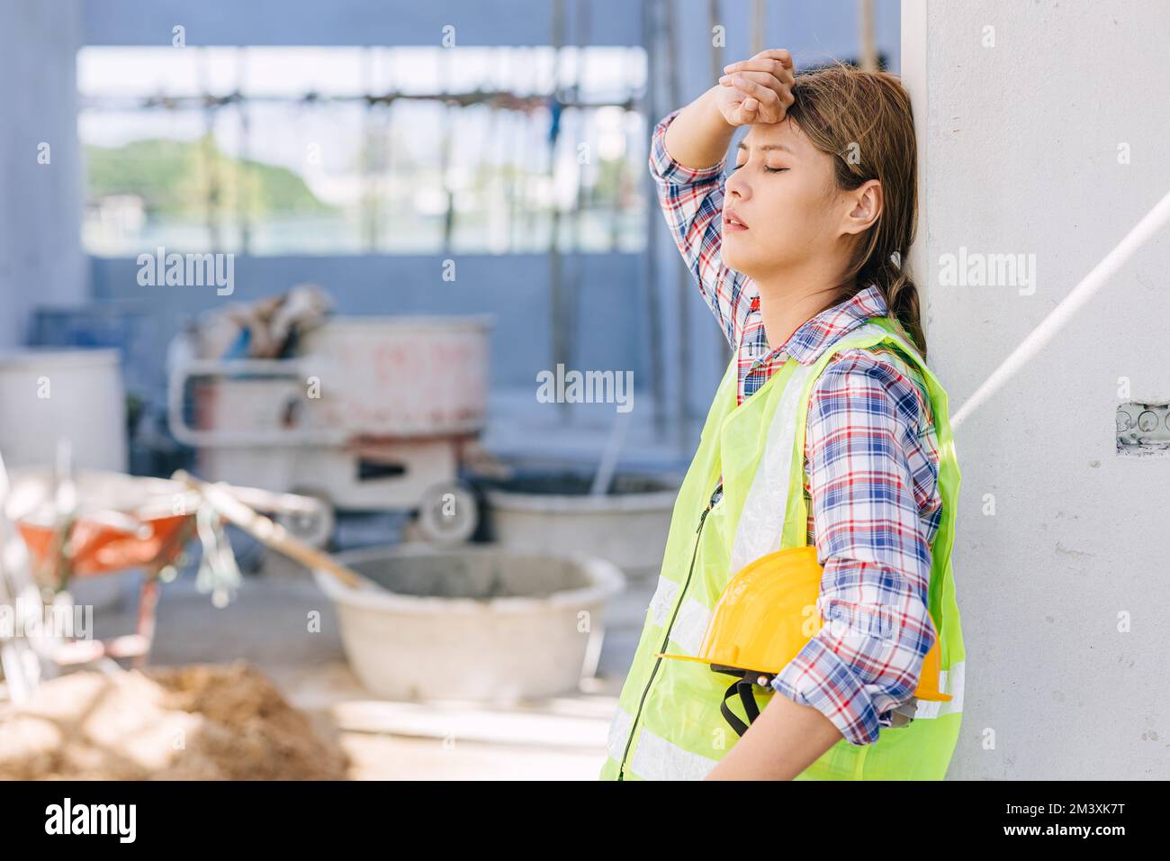 woman worker tired from work hard overwork fatigue be sick at construction site Stock Photo