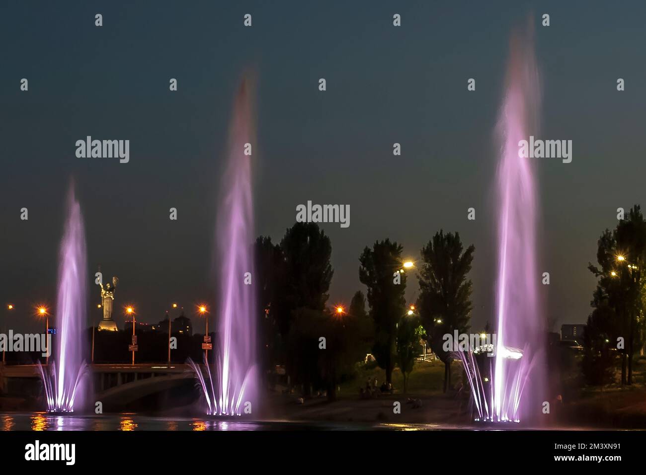 The musician and lighting fountains at the night city Stock Photo - Alamy