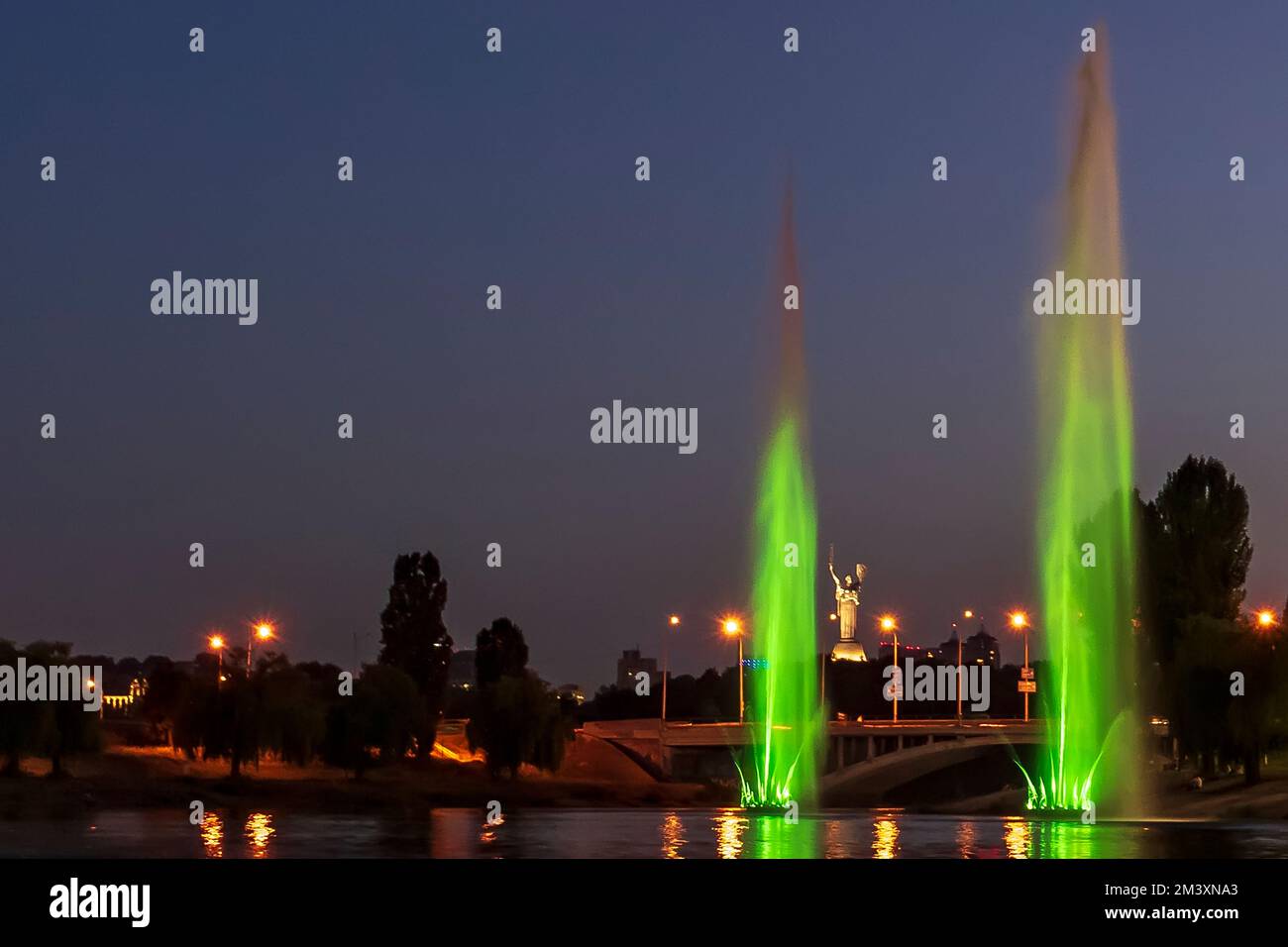 The musician and lighting fountains at the night city Stock Photo - Alamy