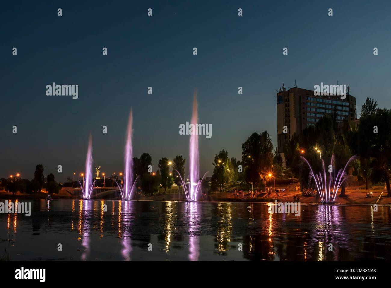 The musician and lighting fountains at the night city Stock Photo - Alamy