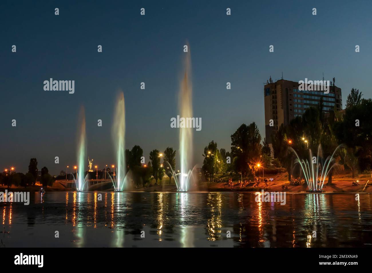 The musician and lighting fountains at the night city Stock Photo - Alamy