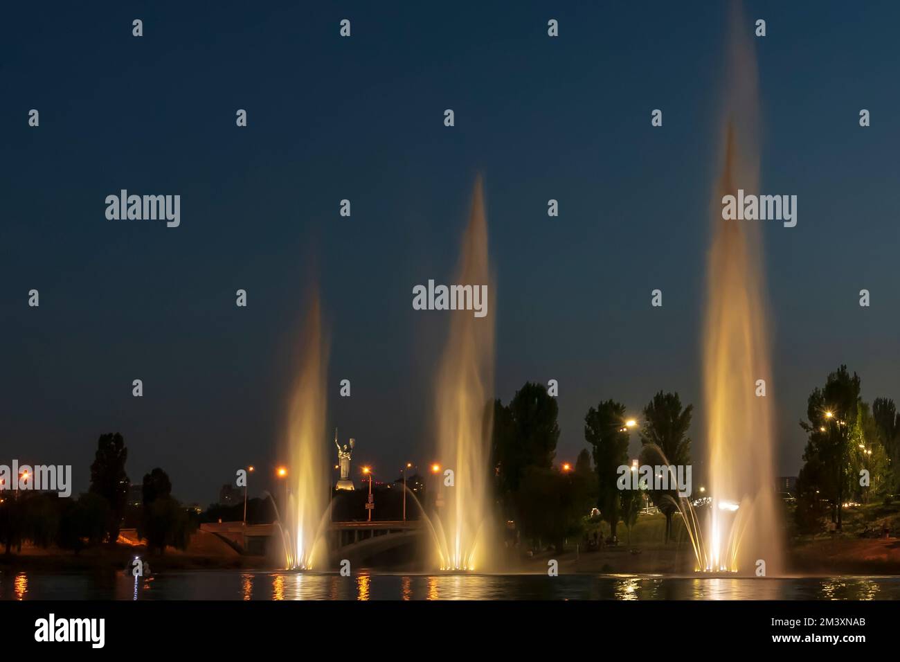 The musician and lighting fountains at the night city Stock Photo - Alamy